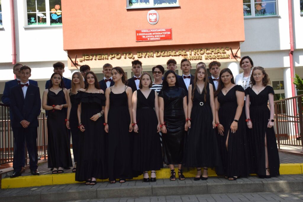 Uczniowie klasy ósmej z wychowawczynią i panią dyrektor na schodach przed budynkiem szkoły