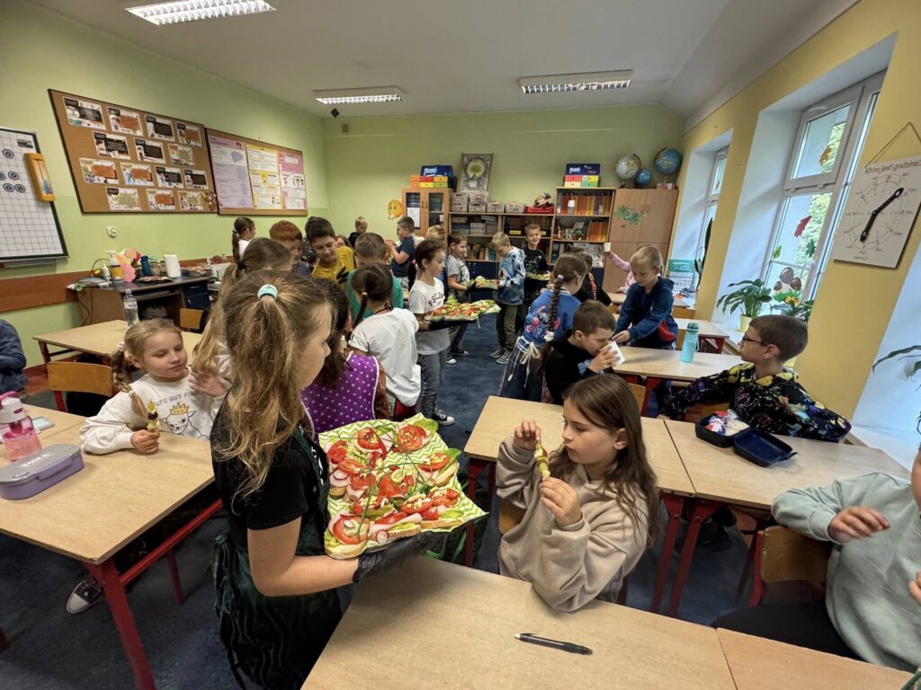 dzieci częstują kolegów kanapkami i lemoniadą