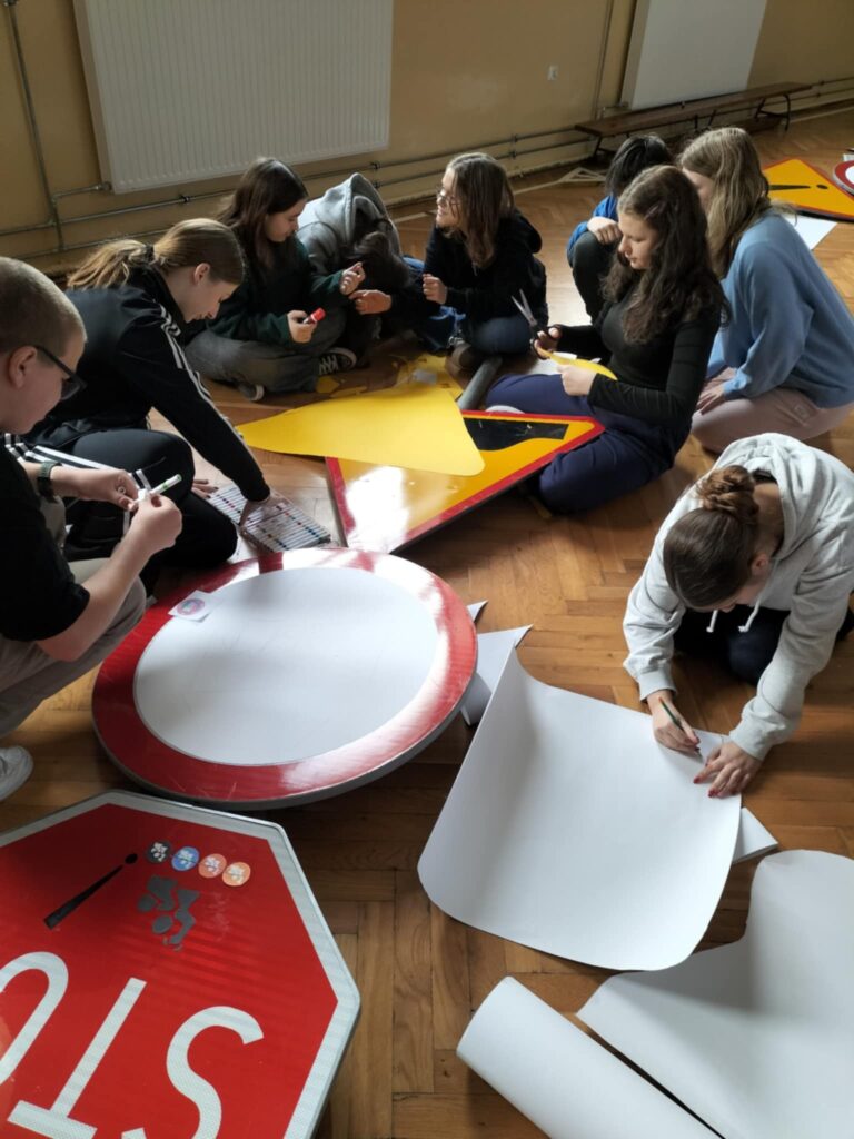 uczniowie przygotowujący znaki drogowe