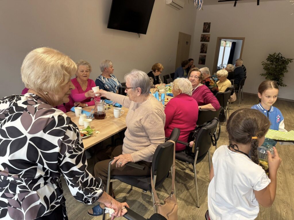 dzieci częstują seniorów kanapkami i lemoniadą