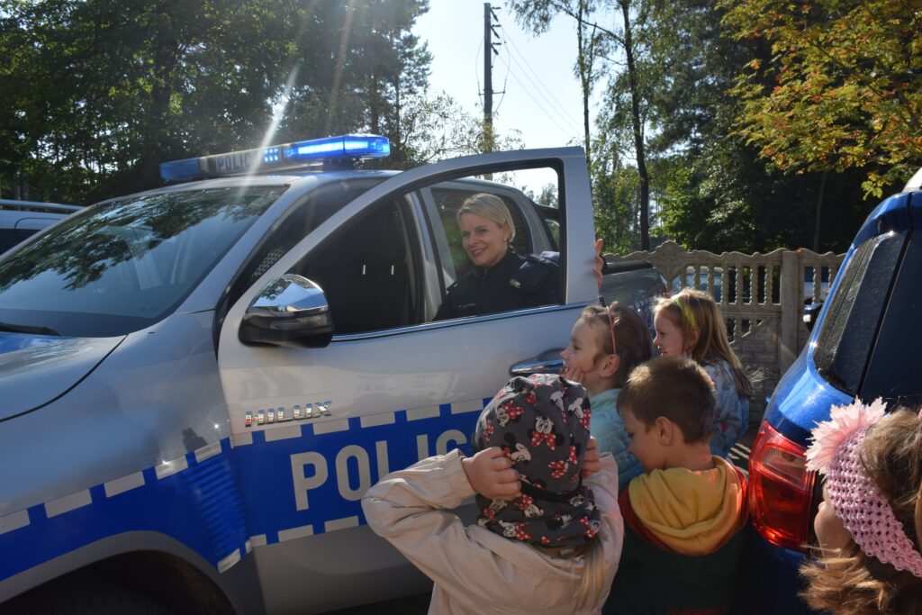uczestnicy festynu przy samochodach policyjnych