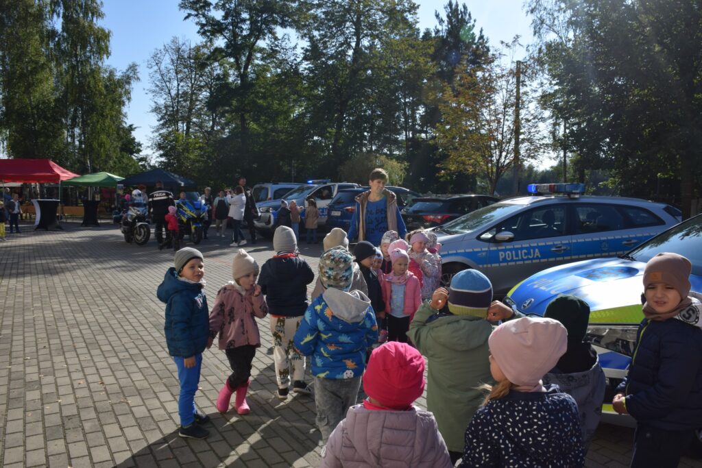 uczestnicy festynu przy samochodach policyjnych