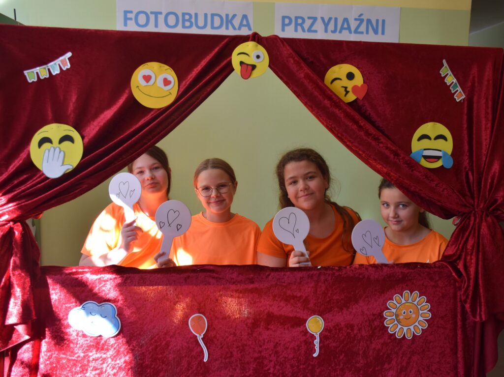 ludzie robiący sobie zdjęcia w fotobudce z fiszkami z dobrymi słowami
