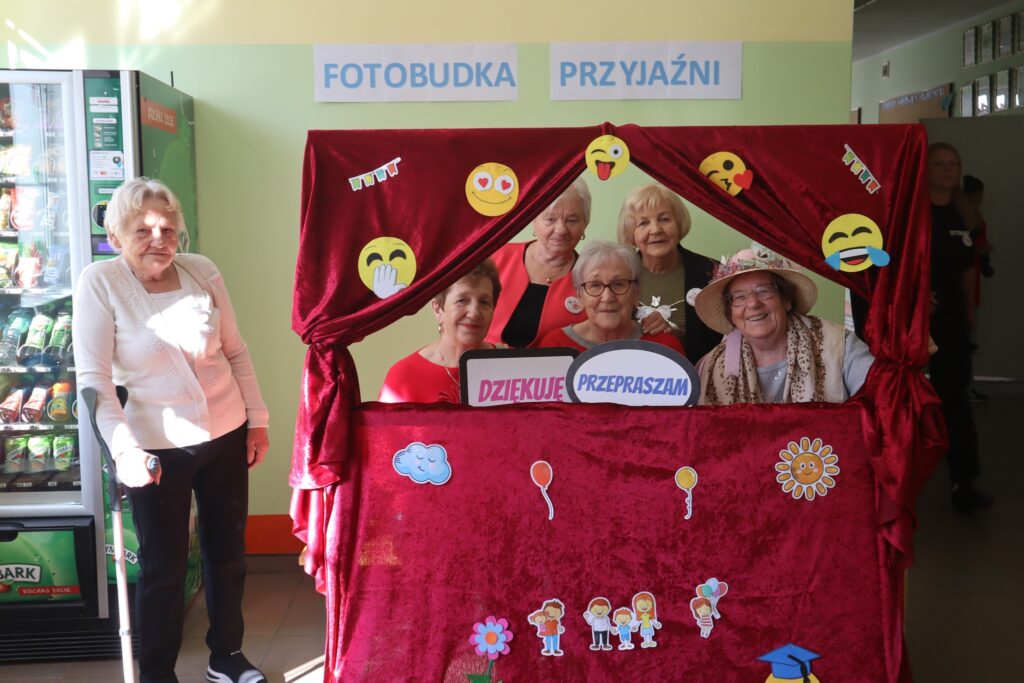 ludzie robiący sobie zdjęcia w fotobudce z fiszkami z dobrymi słowami