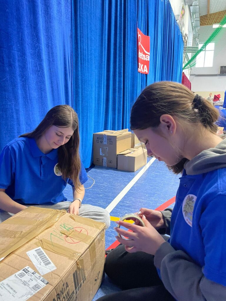 wolontariusze pakujący produkty do szlachetnej paczki