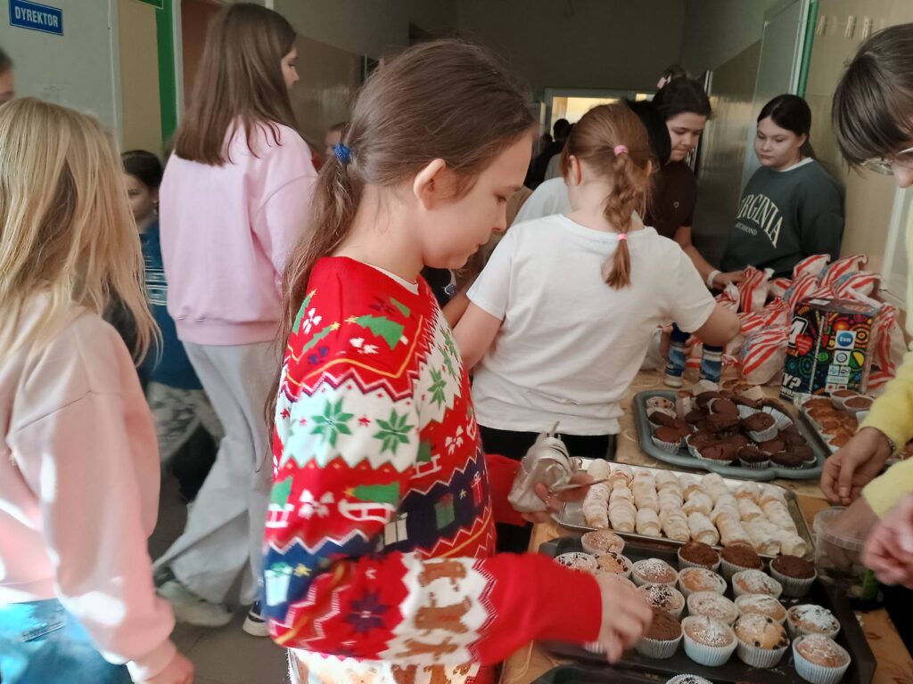 dzieci kupujące babeczki i popcorn