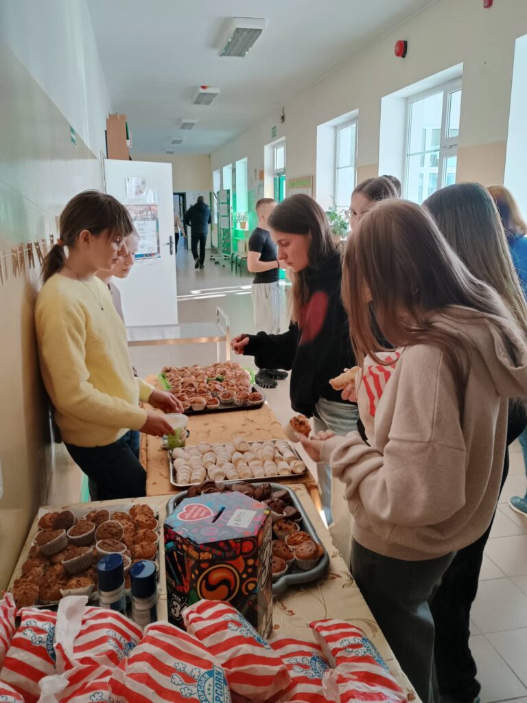 dzieci kupujące babeczki i popcorn