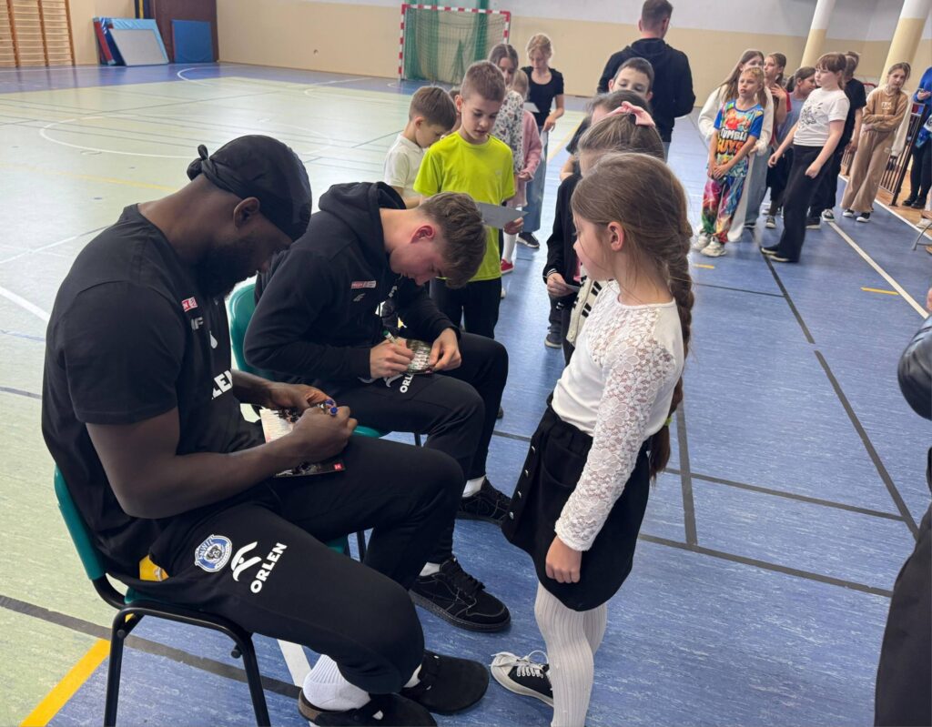 koszykarze Anwilu dający uczniom autografy