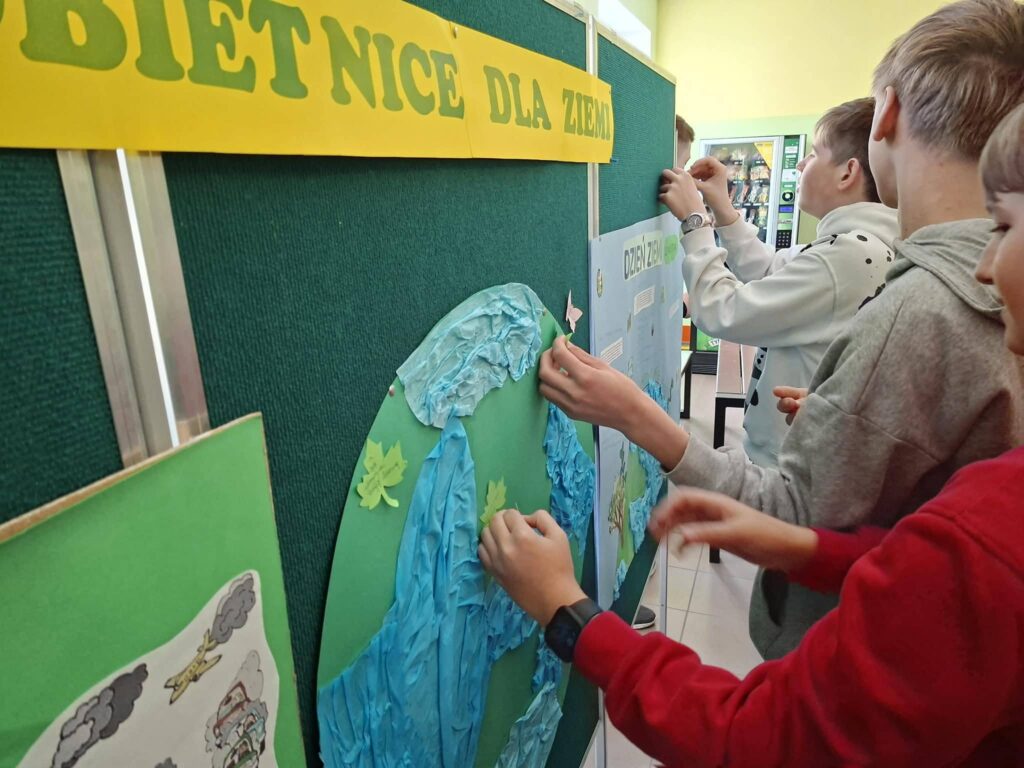 uczniowie przypinający swoje obietnice dla ziemi na tablicy