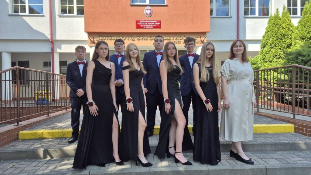 uczniowie klasy 8a z wychowawczynią przed budynkiem szkoły