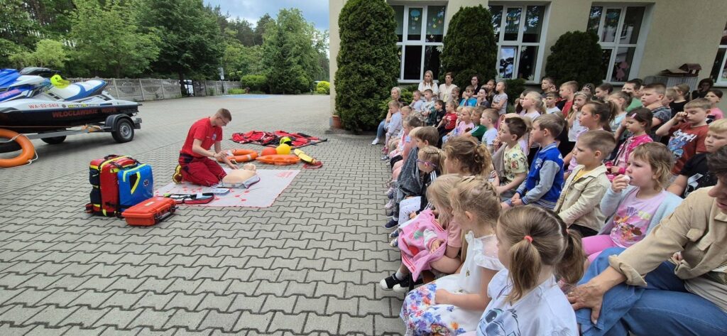 dzieci i ratownicy WOPR ;podczas prezentacji sprzętu ratowniczego i udzielania pierwszej pomocy