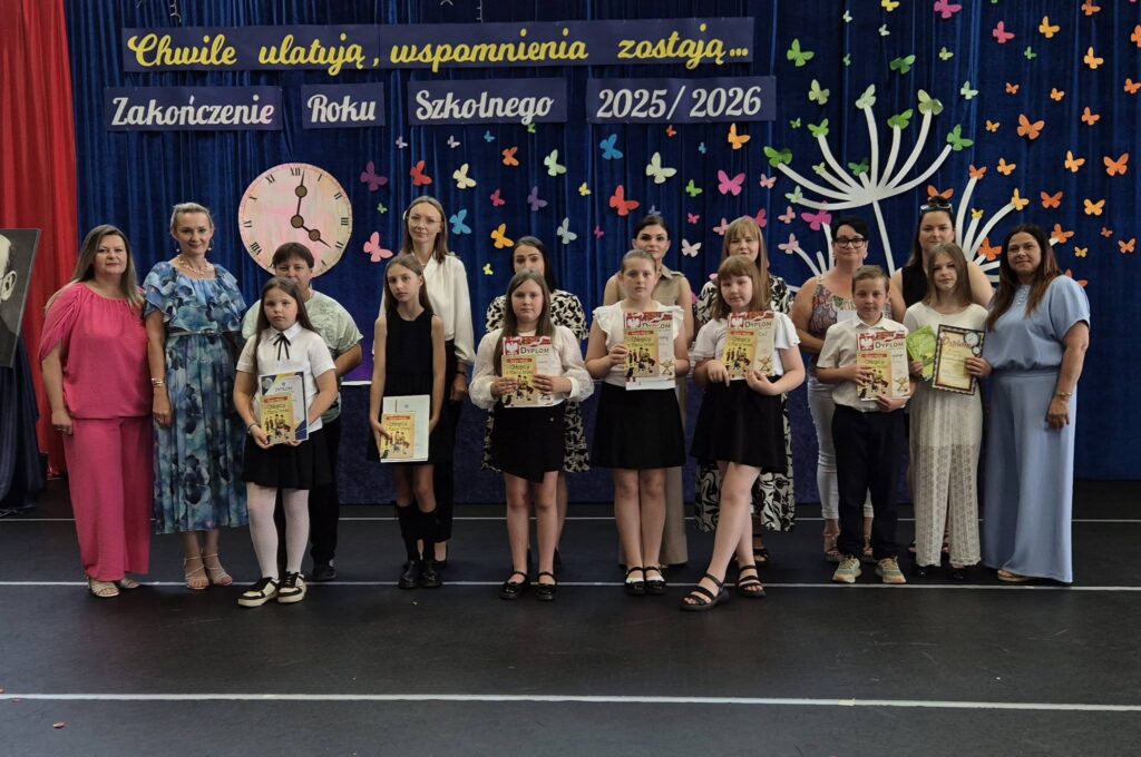 uczniowie klasy czwartej a z świadectwem z paskiem, wraz z rodzicami, wychowawczynią i dyrekcją