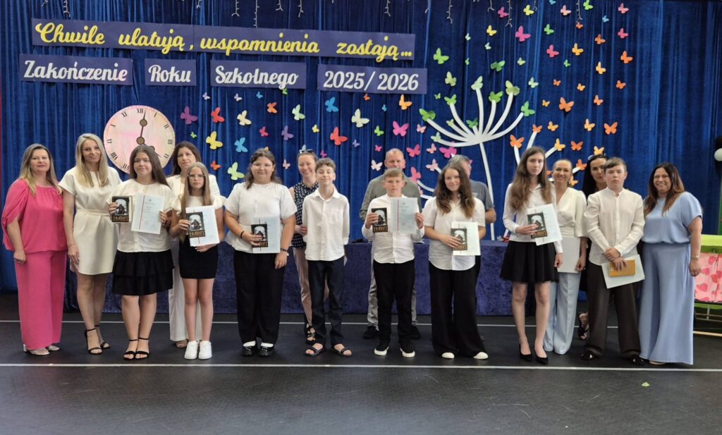 uczniowie klasy piątej z świadectwem z paskiem, wraz z rodzicami, wychowawczynią i dyrekcją
