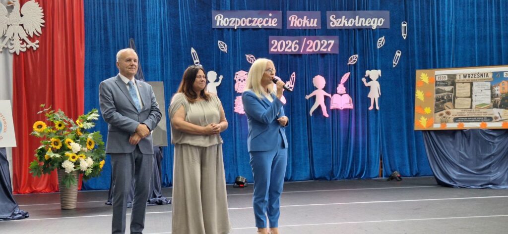 dwie panie i pan na tle dekoracji na rozpoczęcie roku szkolnego