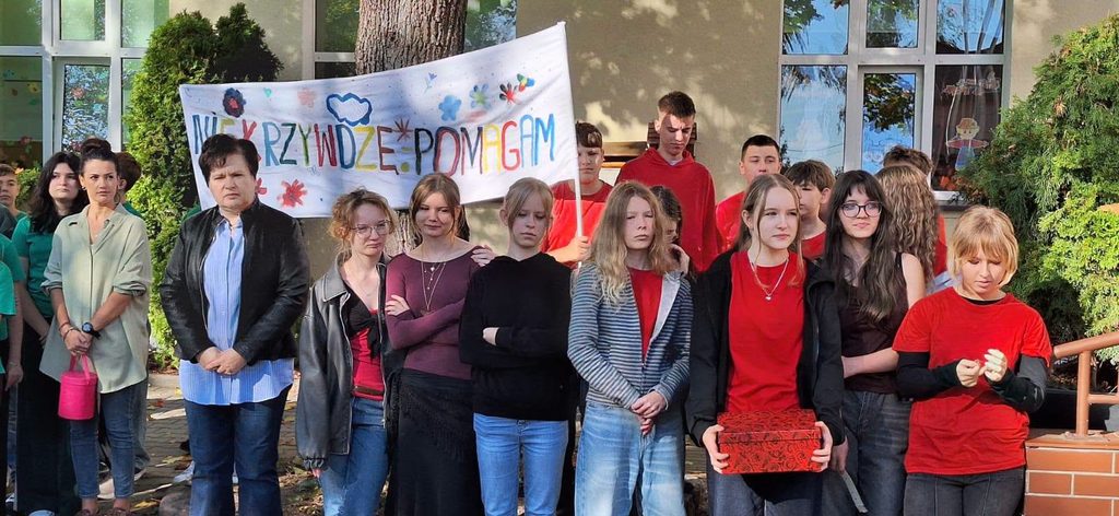 grupa uczniów na tle budynku szkoły