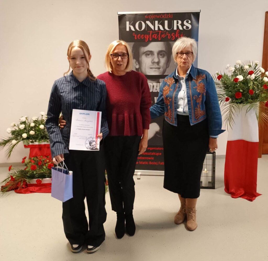 uczennica z dyplomem obok dwie panie z jury konkursu recytatorskiego